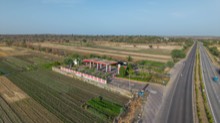 Highway and farmland stretching past the landscaped roadside site