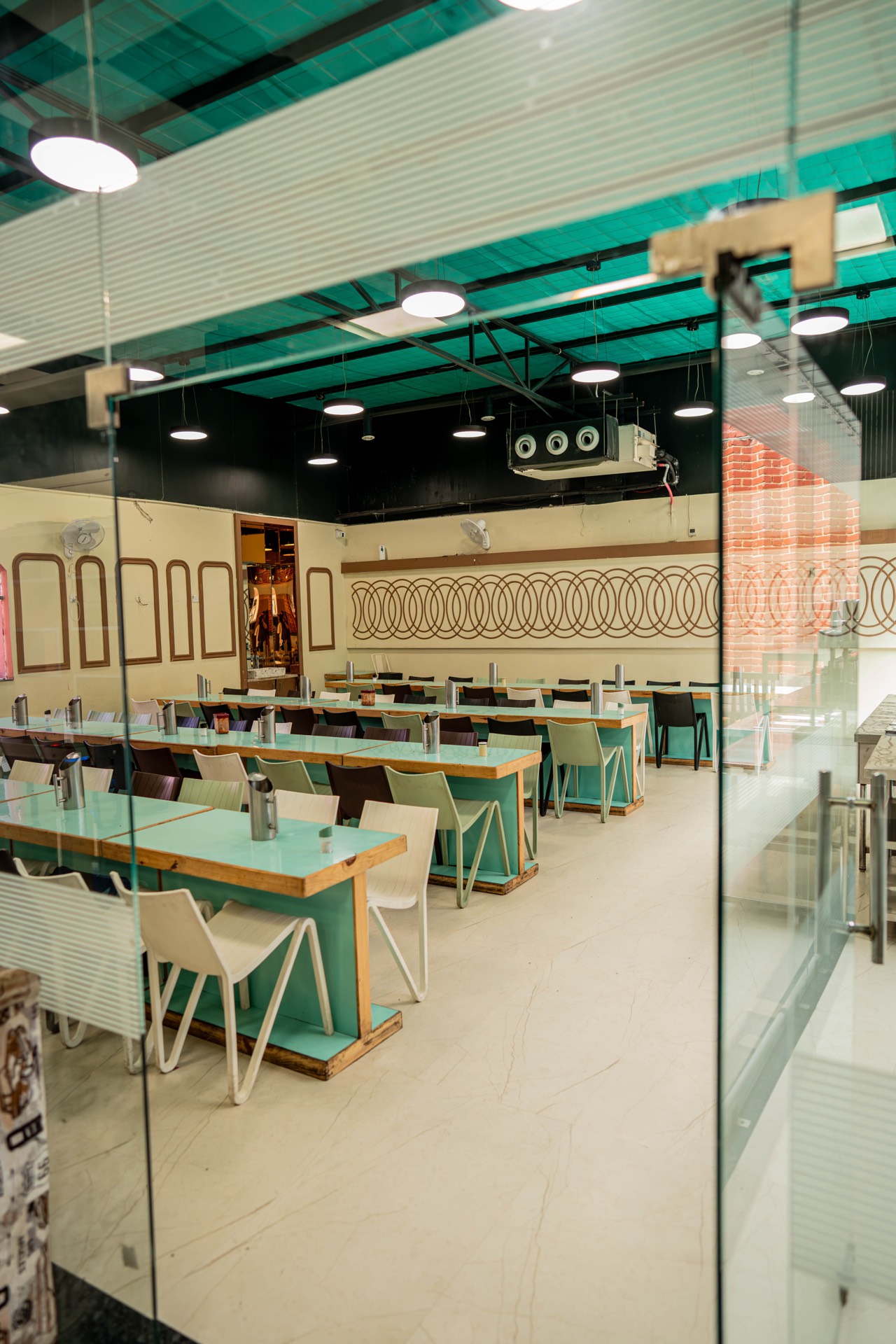 Dining wing seen through the glass partition at Vyanjanam