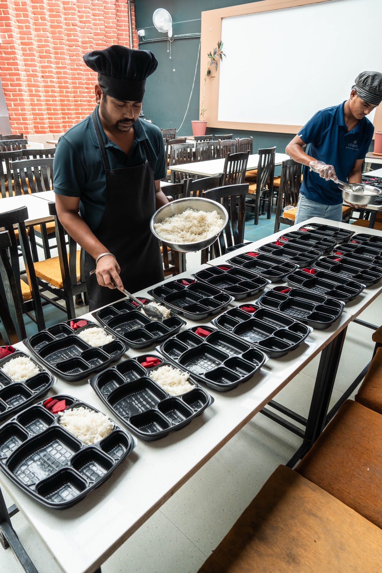 Staff preparing meal boxes at Vyanjanam