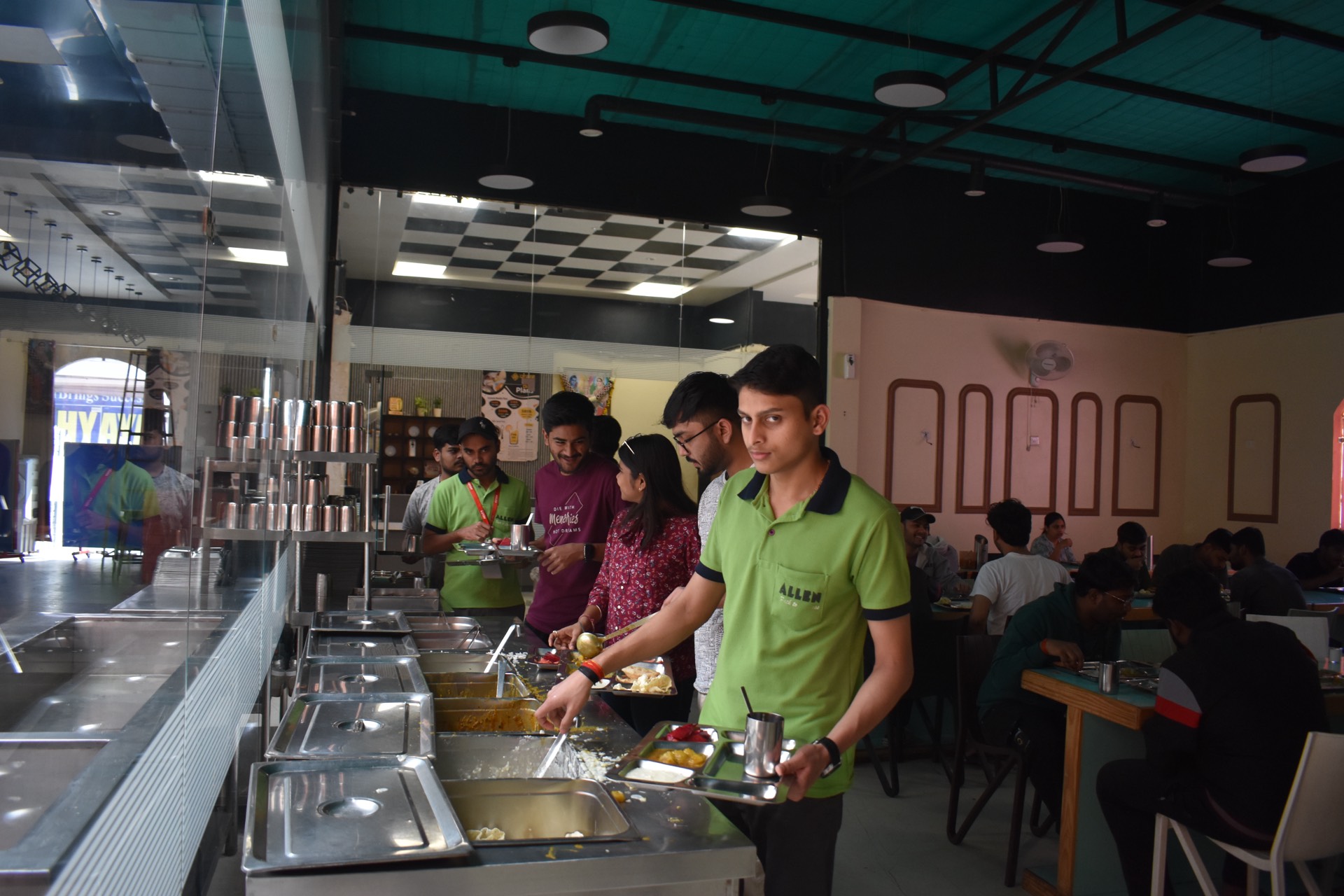 Students serving themselves at the buffet counter in Vyanjanam