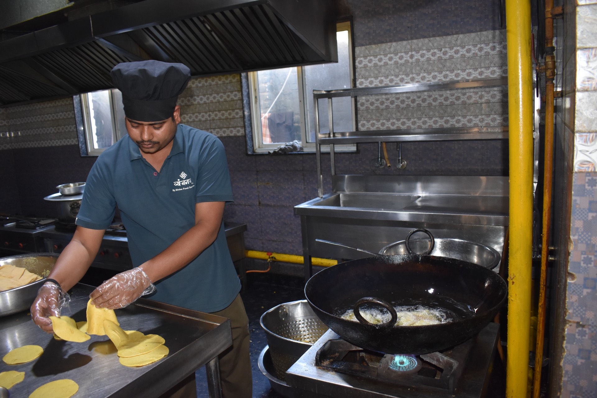 Kitchen staff preparing puris at Vyanjanam