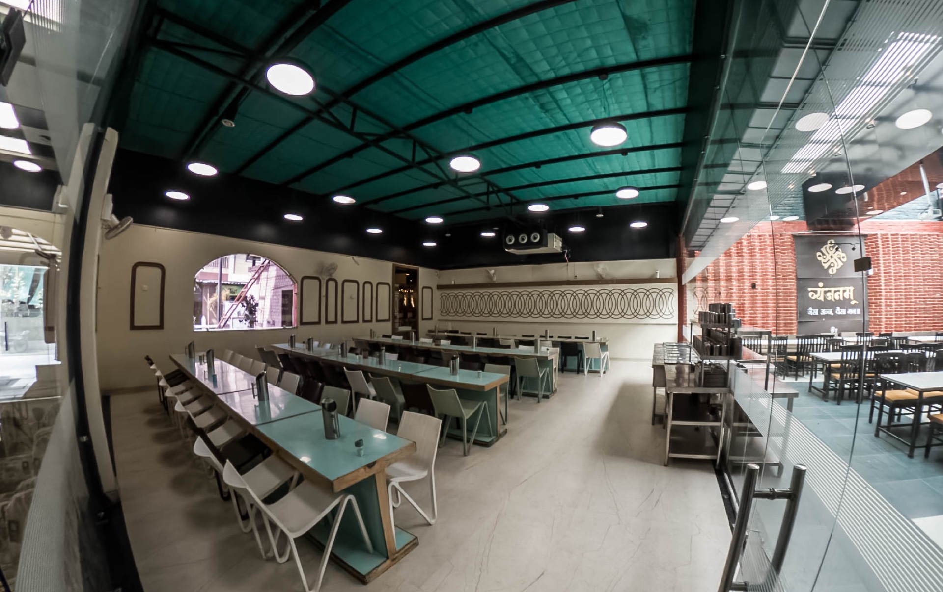 Wide interior view of the left dining wing at Vyanjanam